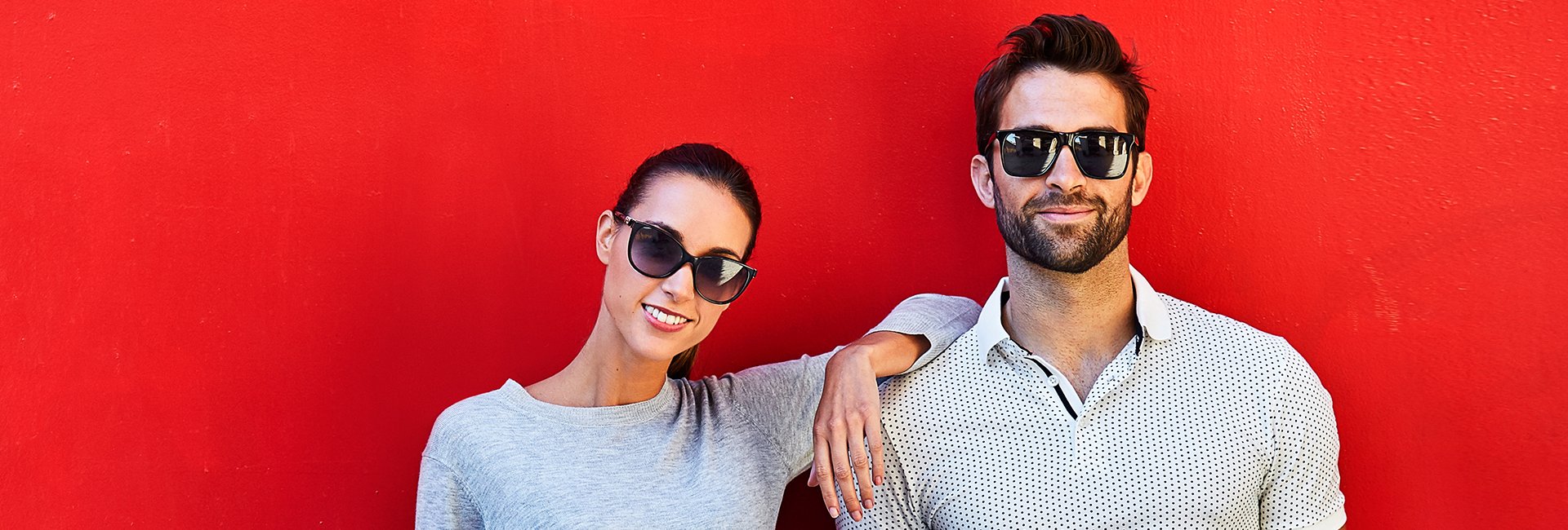 Man and woman in sunglasses smiling